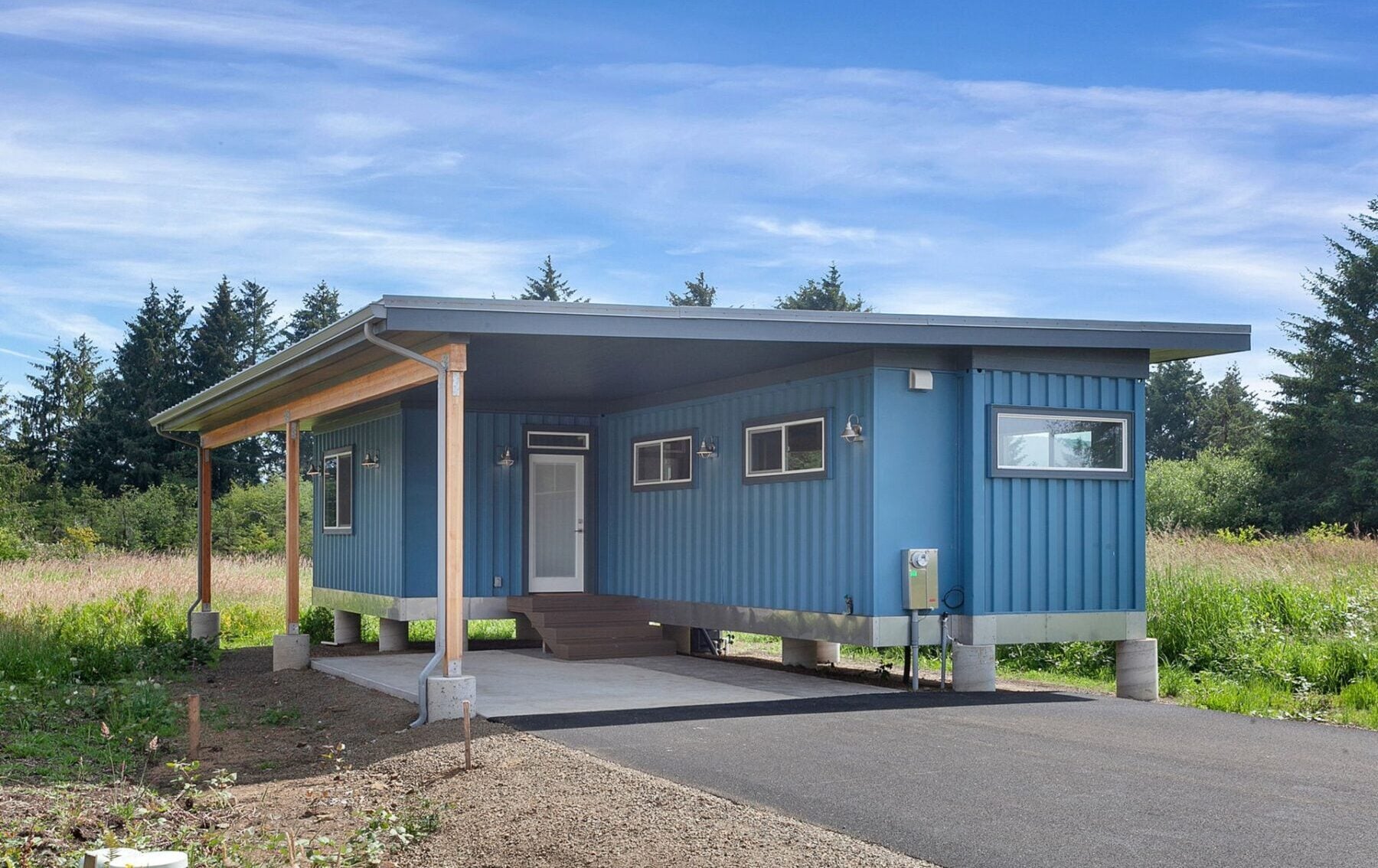 Sleek blue shipping container home with sustainable materials and modular design, showcasing eco-friendly residential architecture.