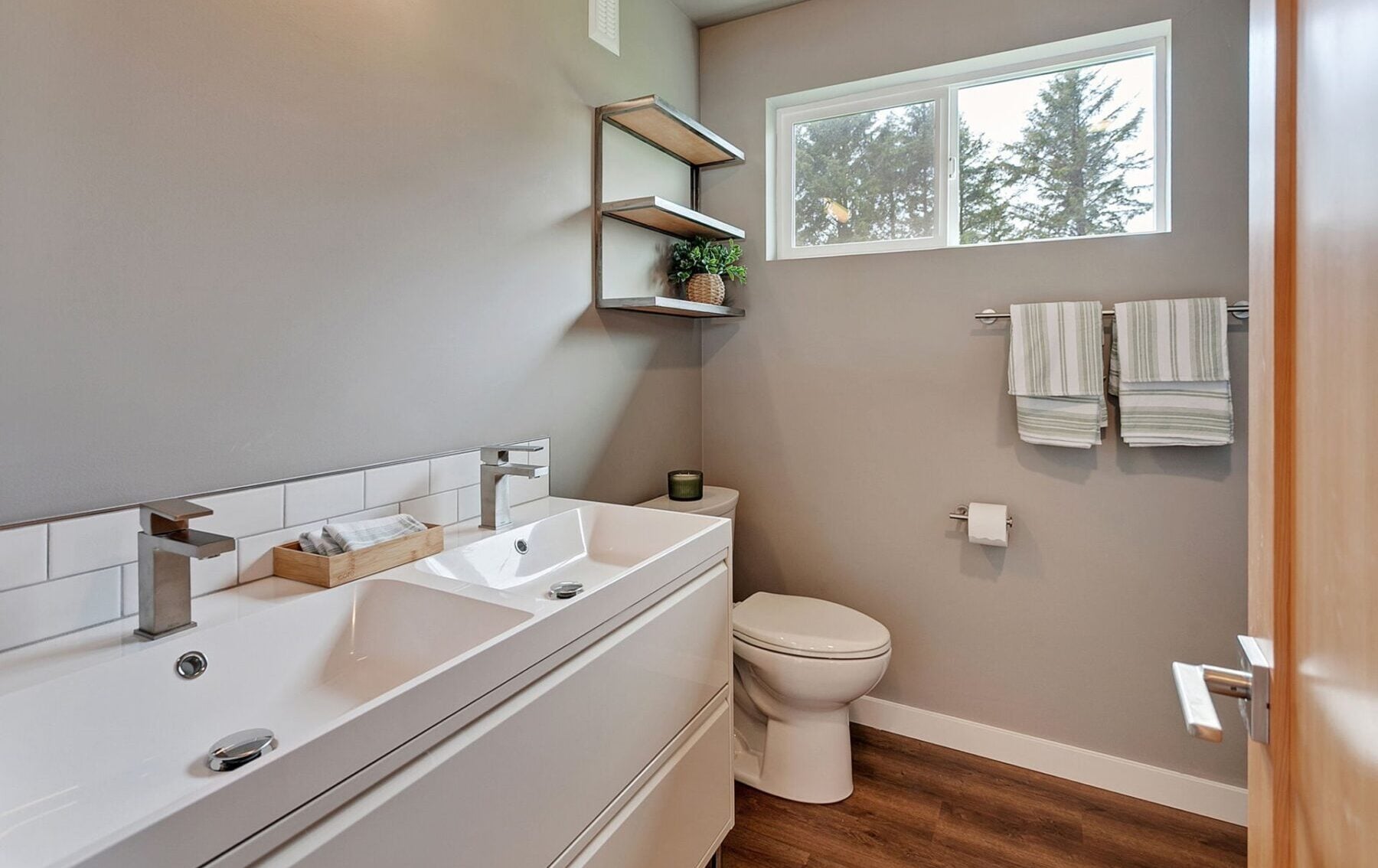 Modern container home bathroom featuring dual sinks, eco-friendly finishes, and modular design elements for sustainable living.