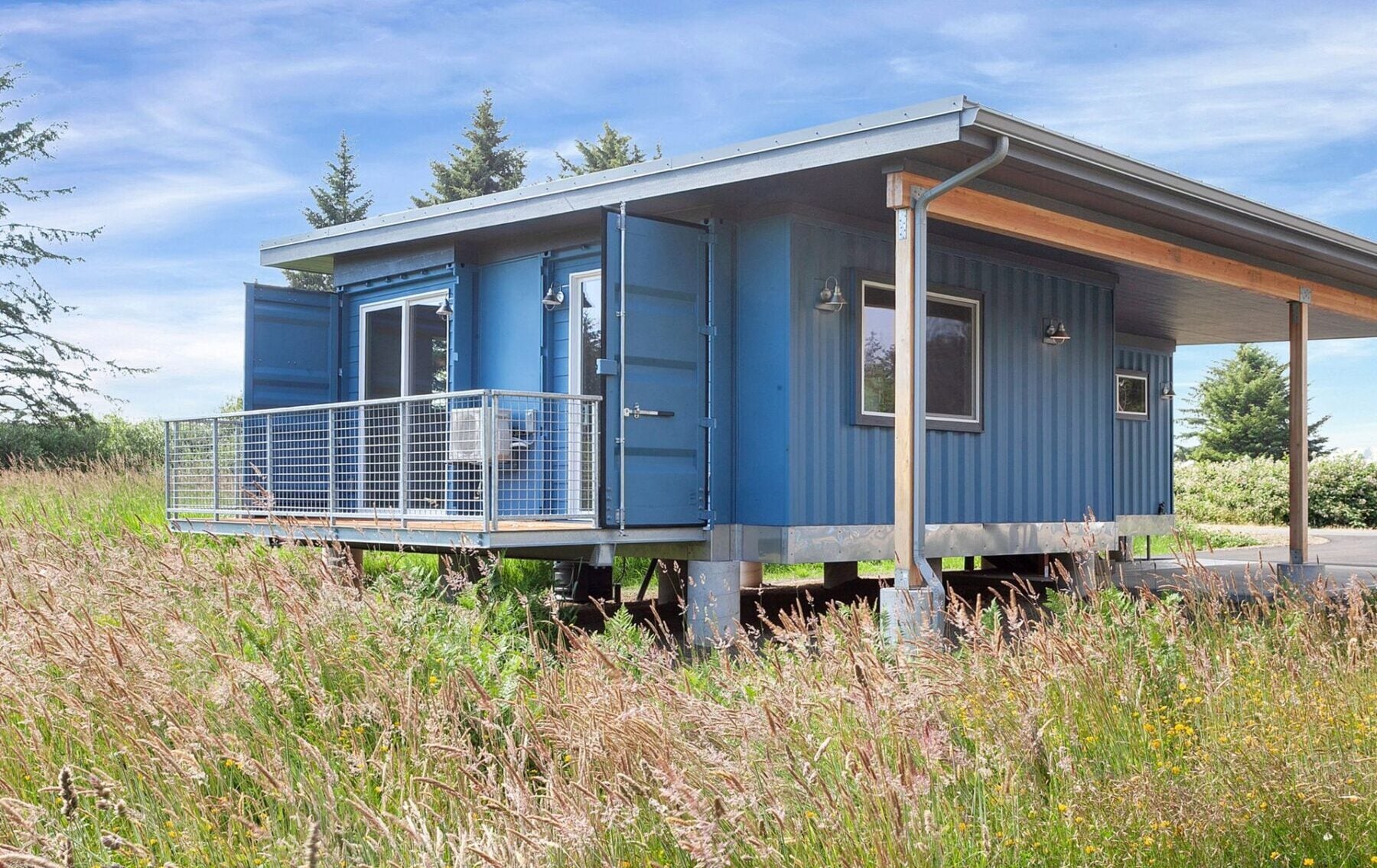 Modern shipping container home with a deck, showcasing sustainable design and modular construction for eco-friendly living.